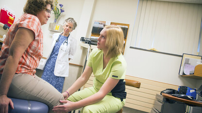 Ashley Stelling, a student in the Humanities in Medicine program, examines a patient in the University Health Center. Management of the UHC will transfer to the University of Nebraska Medical Center on July 1.