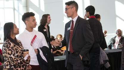 Jackson Wu-Pong (right) talks with an Omaha-area family prior to the Nebraska Achievement Recognition Program on Nov. 18. The event celebrated the achievement of more than 600 high school students from around Omaha.