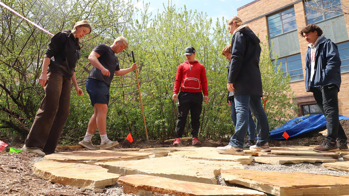 Students in Introduction to Landscape Construction work as a team, fitting flagstone pieces together like a puzzle as they build a patio.