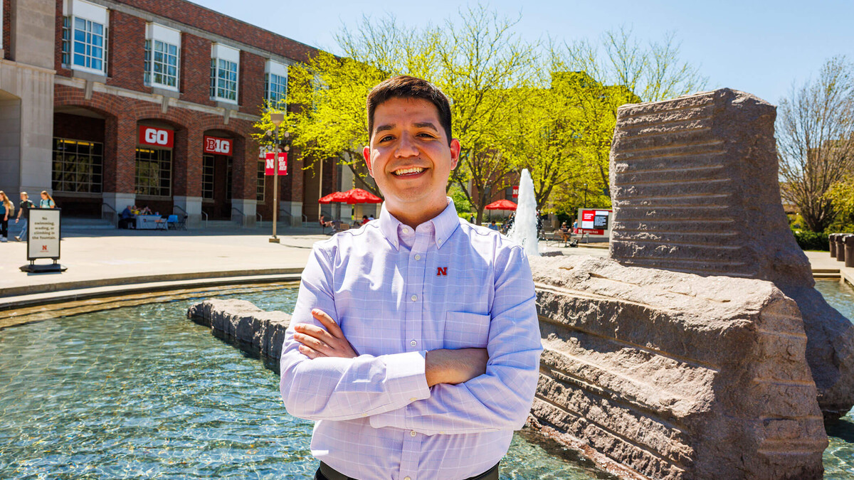 Lupe Perez, the assistant director of campus visits, stands in front of the Nebraska Union and Broyhill Fountain on a sunny spring day. Photo by Kristin Labadie University Communication.