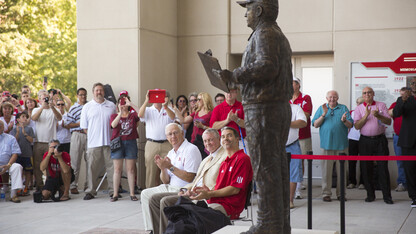 Mike Devaney, (Bob Devaney's son), Tom Osborne, the Cornhuskers' former head coach and athletic director, and Rob Devaney (Bob Devaney's grandson), look up at the just dedicated statue of Bob Devaney.  A commissioned statue of Hall-of-Fame football coach and former Cornhusker athletic director Bob Devaney was installed in the new East Memorial Stadium plaza Friday afternoon. 