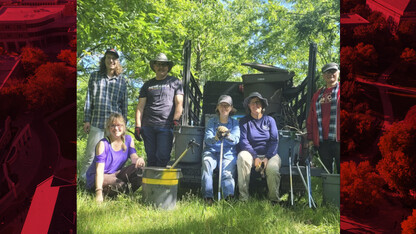 Jennifer Weisbrod (crouched on the left), John Hay (directly left of the truck), and volunteers in front of the truck that was used to assist the removal of trash in the creek.