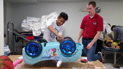 Two engineering students rewire an electric car during at the Go Baby Go build on Oct. 15.