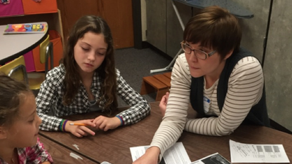 UNL doctoral student and entomologist Erin Ingram works with Evelyn Hamlow Elementary School students Grace Ehlers and Addison Stephens on a project focused on saving honey bees. 