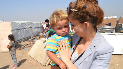Vianne Sheikh consoles a toddler at a refugee camp in Iraq. The Husker is working to elevate stories of refugee women.