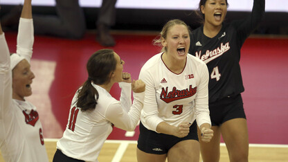 Husker volleyball players celebrate during a match.