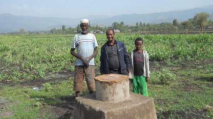 Tsegaye Tadesse, center, with a farmer and son at an irrigation demonstration site near Harbu, Ethiopia.