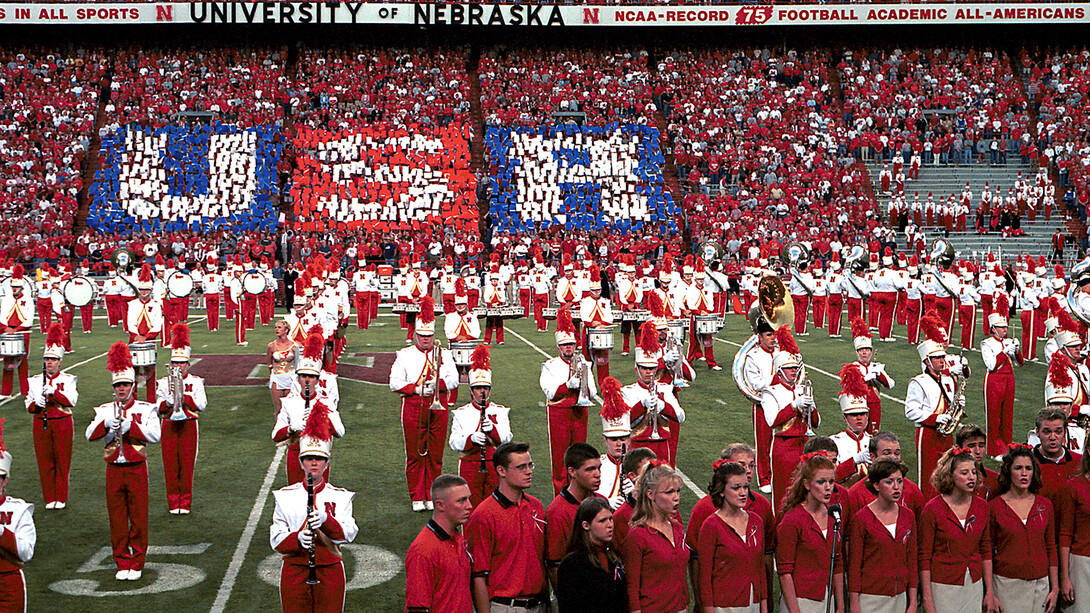 Band members and singers stand on the Memorial Stadium turf as fans lift red, white and blue cards to spell out "USA" during Sept. 20, 2001 pregame activities.
