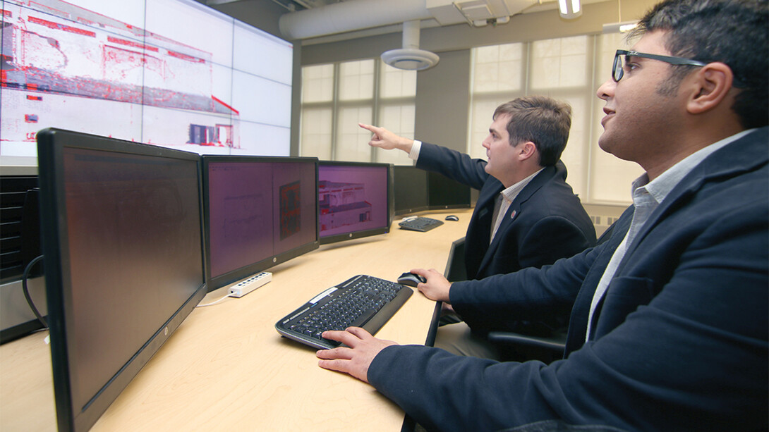 Nebraska civil engineers Richard Wood (back) and Ebrahim Mohammadi demonstrate images captured while developing 3-D software that can visually identify damage to structures.