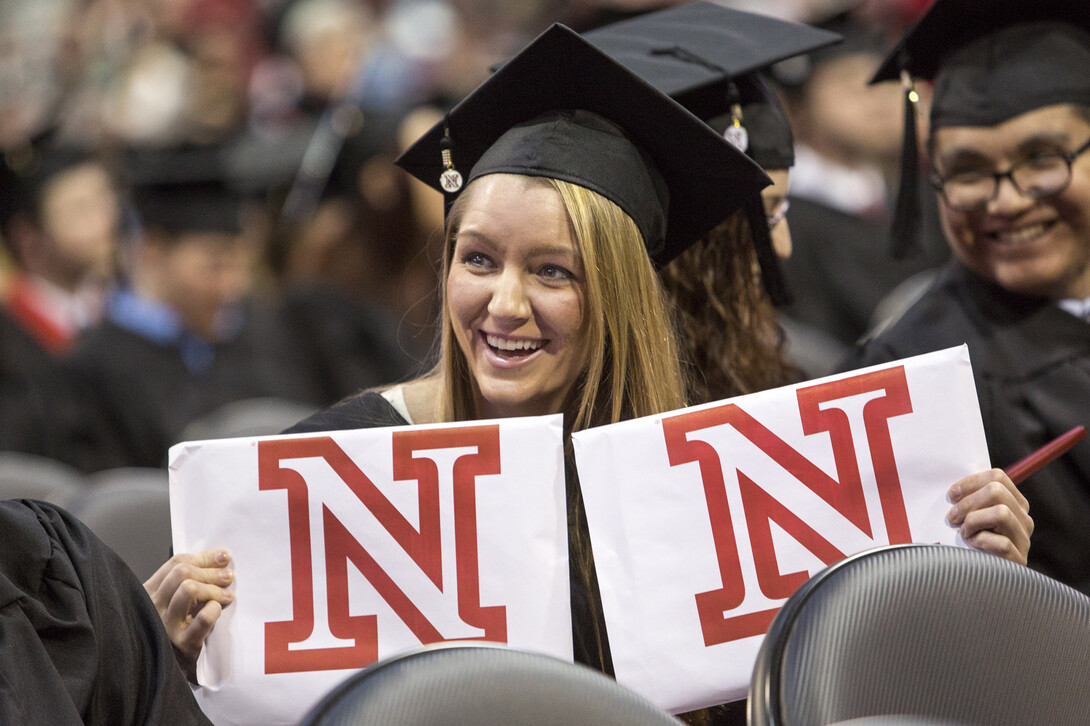 Lucy Myrtue shows her degree diplomas in theater and music education to her parents.