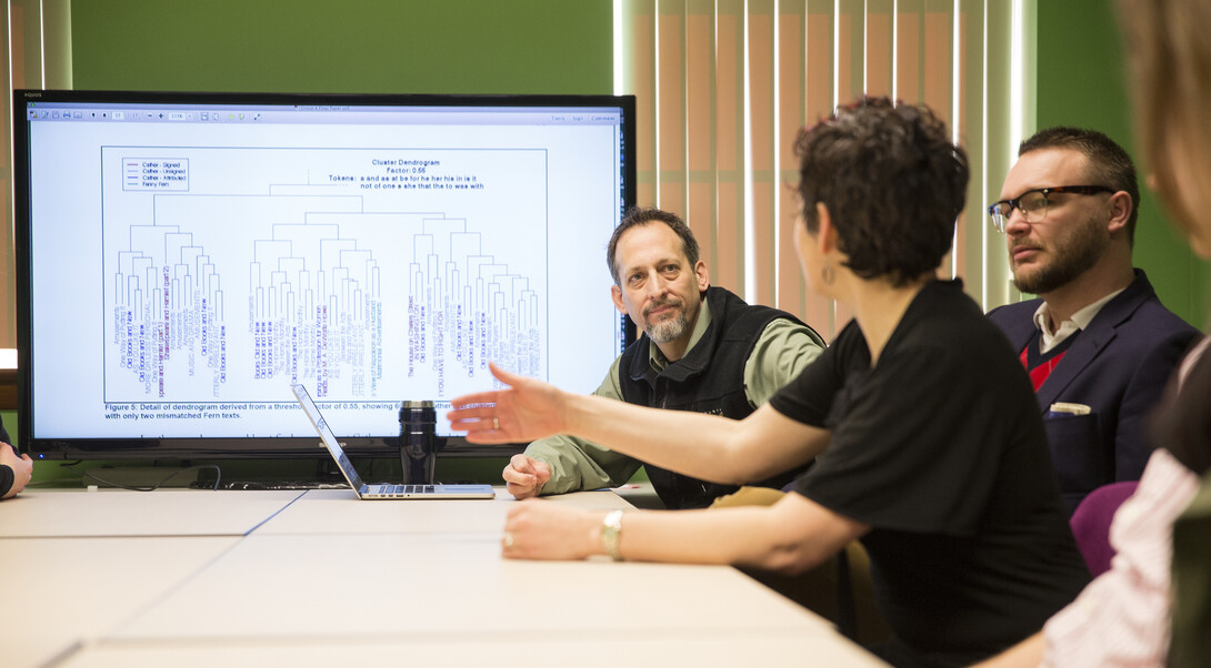 Matthew Jockers (left) discusses with students at the Nebraska Literary Lab their digital projects examining the language of Willa Cather.