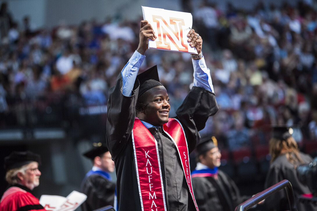 LeRoy Ford holds up his diploma for his family and friends to see. 