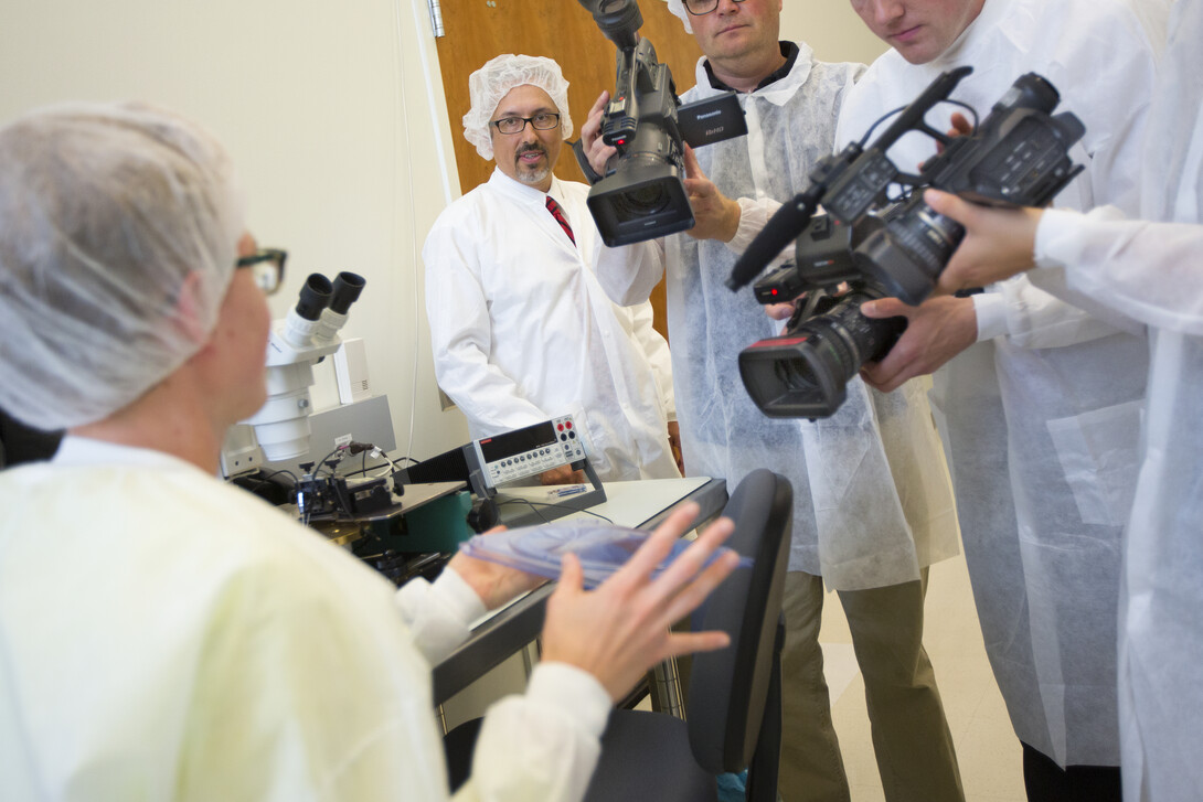 UNL physicist Aaron Dominguez watches as media film particle detector chips in the High Energy Lab in Jorgensen Hall.