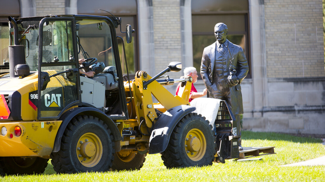 Workers use a tractor to position the new life-sized sculpture of J. Sterling Morton on East Campus on Sept. 8. The sculpture is one of four honoring Nebraskans who have served as U.S. Secretary of Agriculture.