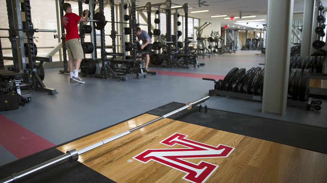 UNL students and Campus Recreation employees (from left) Joe Grobeck and Nate Morhardt place weights on a compound rack in the new East Campus Recreation and Wellness Center. The new $14.89 million facility will host open houses July 8-10 before opening July 13.