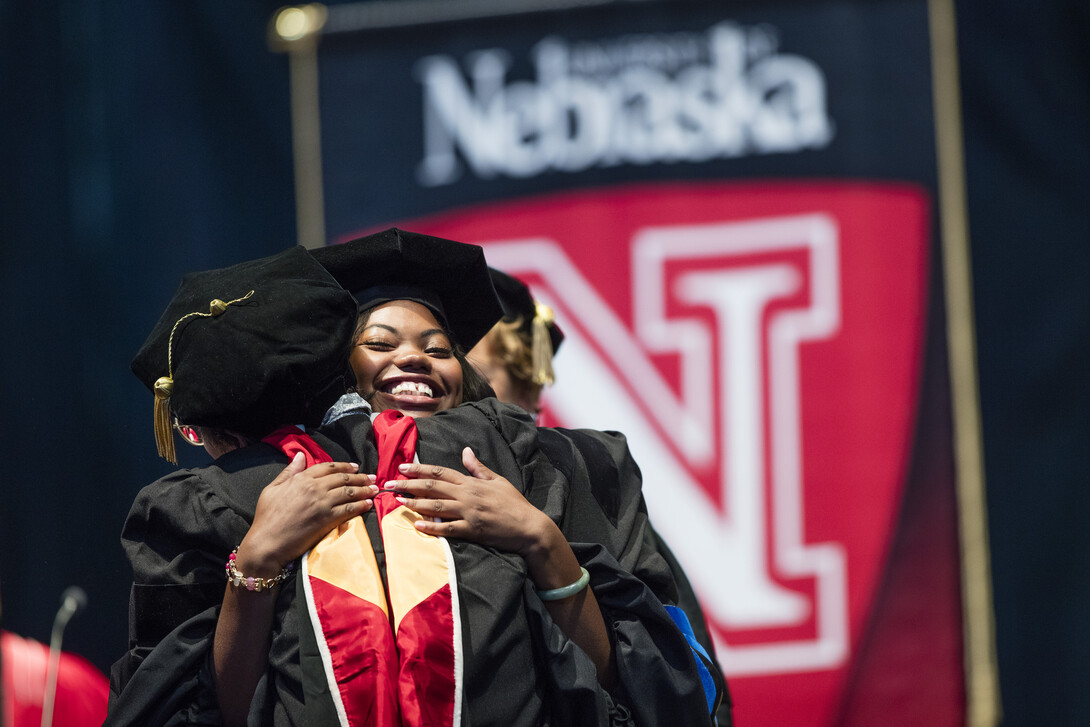 Anisah Numan, is hugged by her professor, Susan Hermiller, after Numan was awarded her doctorate in mathematics.