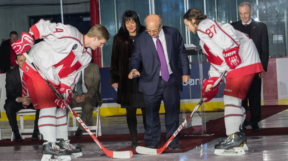 Sonia and John Breslow (center) drop a puck during a ceremonial dedication of UNL's new $11 million John Breslow Ice Hockey Center on Feb. 3.