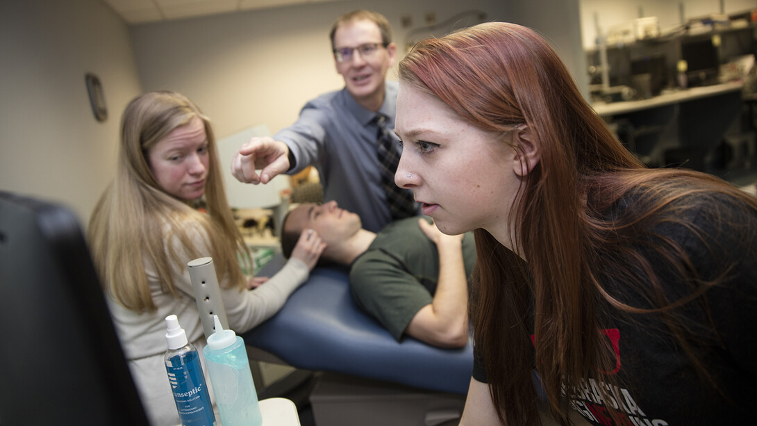 Nebraska students Madison Burger and Allison Porter work with Greg Bashford as part of a UCARE project in 2016. Part of the work, shown here, included using a device that measures brain waves through eyelid pressure.