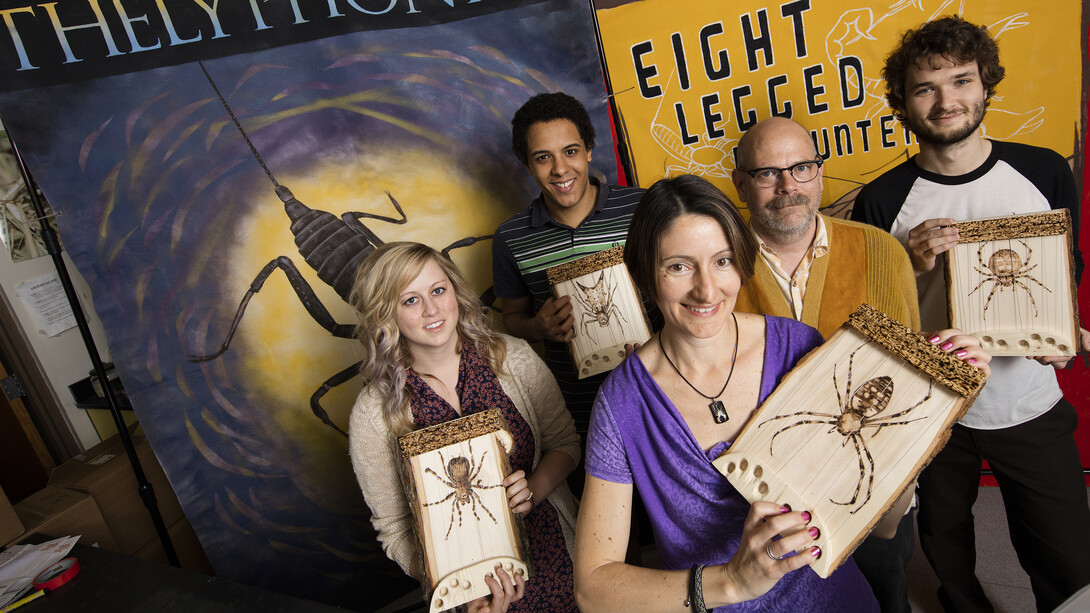 A team led by Eileen Hebets (front, in purple) holds spider-shaped dulcimers from the "Eight-Legged Encounters" exhibition. The dulcimers are used as a teaching tool to show how spiders feel vibrations through their legs.