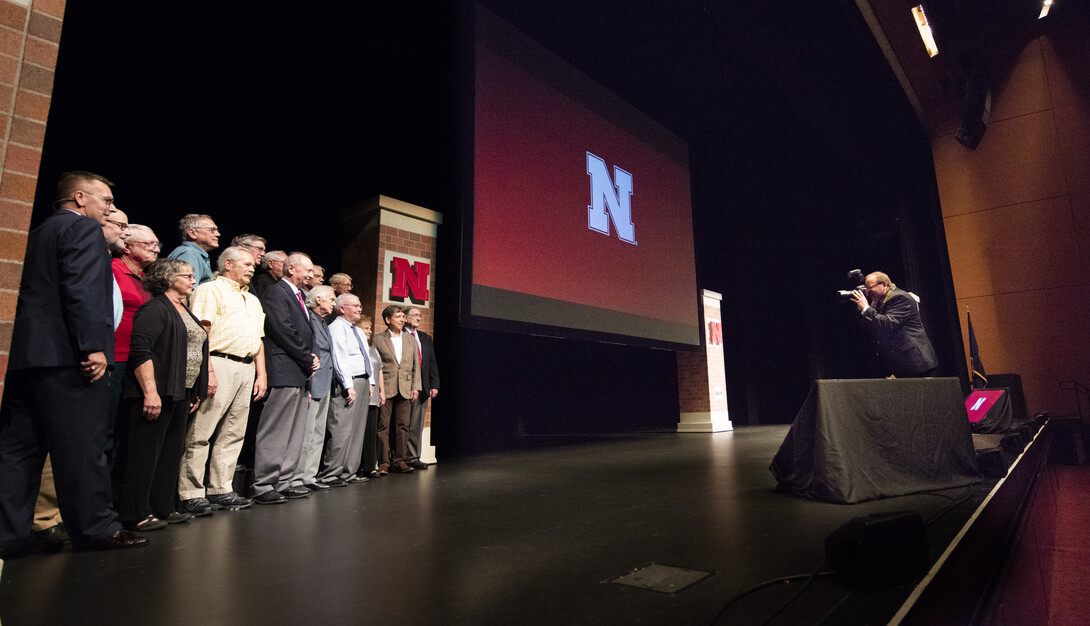 Employees honored for their years of service to the university pose for a photo on stage during the Sept. 22 State of the University address. More than 890 employees are receiving awards for their years of service in 2016.