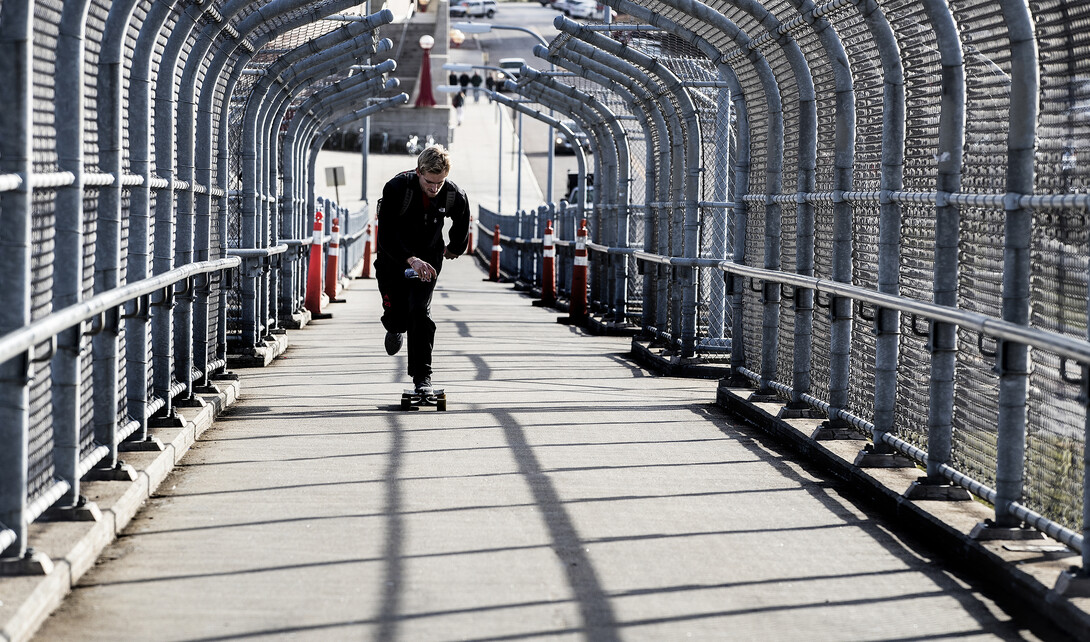 A skateboarder accelerates up the 10th Street pedestrian bridge. The walkway will be closed for a maintenance project on Feb. 20.