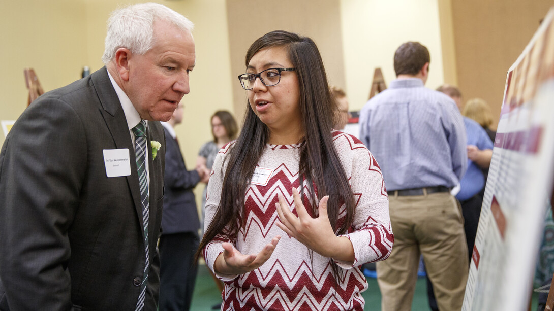 Reiza Izabel Sebastian explains her research into language development of Spanish-speaking and English-speaking preschoolers to District 1 Sen. Dan Watermeier.