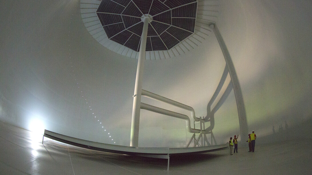 .Employees examine the inside of the thermal energy storage tank before it is sealed for filling and testing. Baffles at the top and bottom will reduce water circulation within the tank. The holes along the tank at left will hold temperature gauges that will allow for monitoring along the entire 100-foot height of the tank.