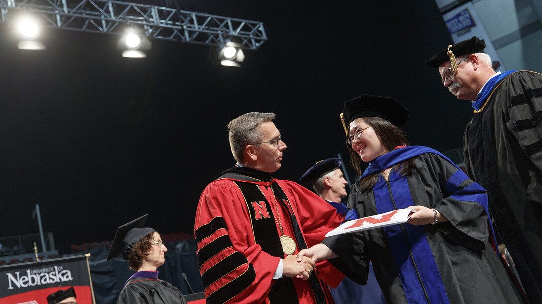 Chancellor Ronnie Green shakes hands with a graduate during summer commencement exercises. Nearly 700 degrees were awarded on Aug. 12.