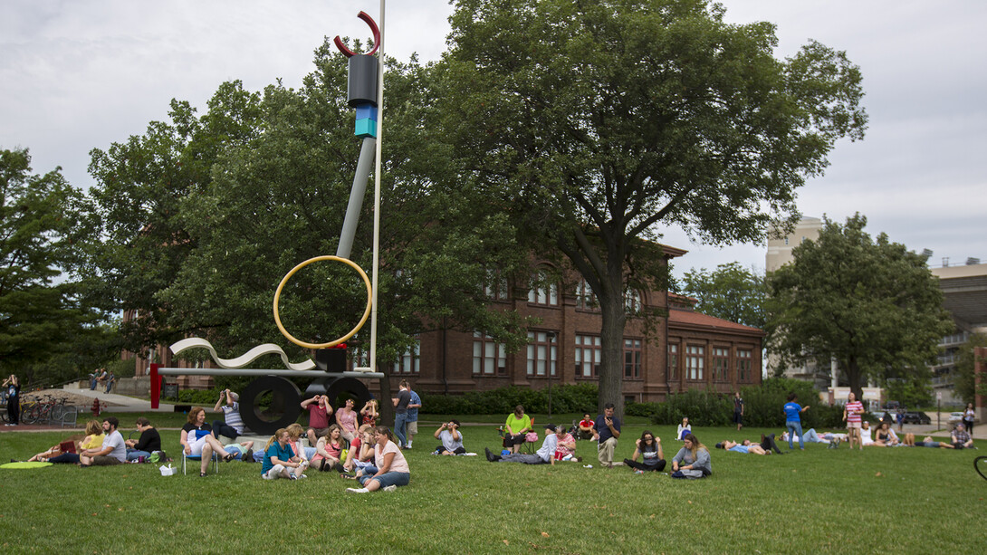 Students, faculty and staff view the eclipse on the green space south of Manter Hall.