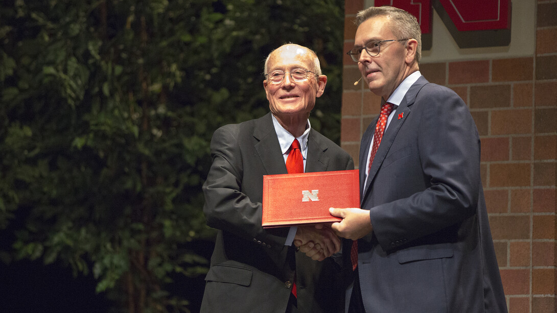 Larry Walklin, professor of broadcasting, accepts a 50-year service award from Chancellor Ronnie Green during the State of the University address on Sept. 19. Walklin was among 13 employees honored for 45- or 50-years of service to the university.