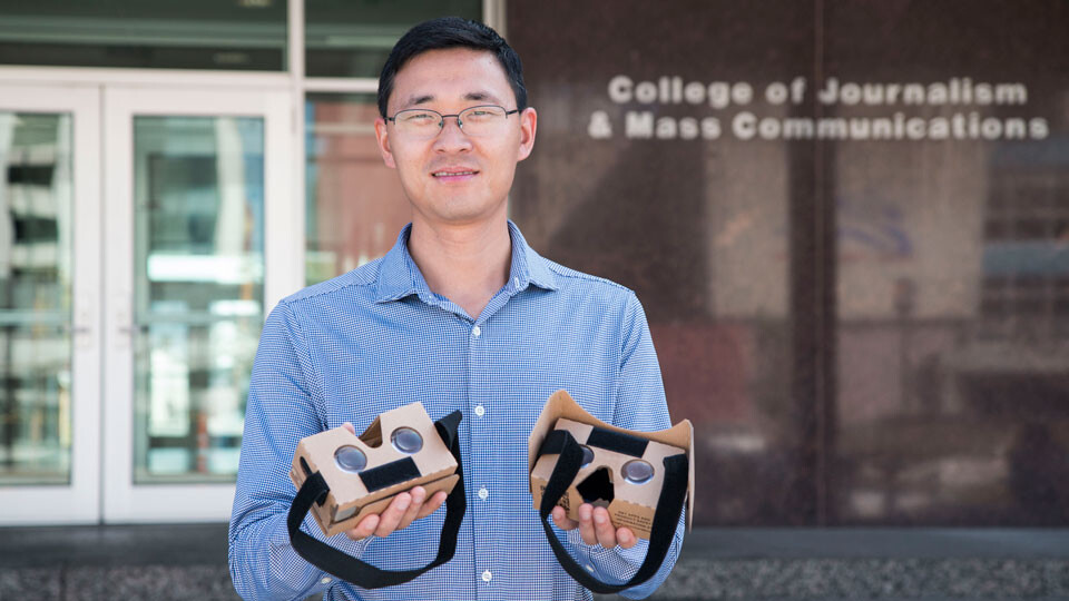 Changmin Yan holds Google Cardboard glasses used in his team's virtual reality game.