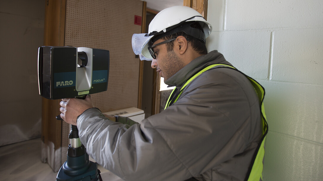 Ebrahim Mohammadi, a doctoral student who works with Richard Wood, operates a lidar sensor on the 11th floor of Pound Hall on Dec. 2. The research team is using the device to create maps of each floor of the residence hall.