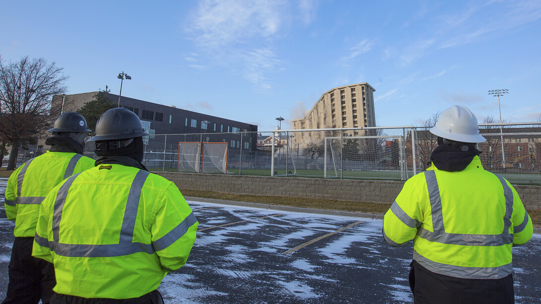 Nebraska and Ark Demolition employees watch as Cather and Pound halls fall on Dec. 22. The two 13-story residence halls were razed via controlled implosion.