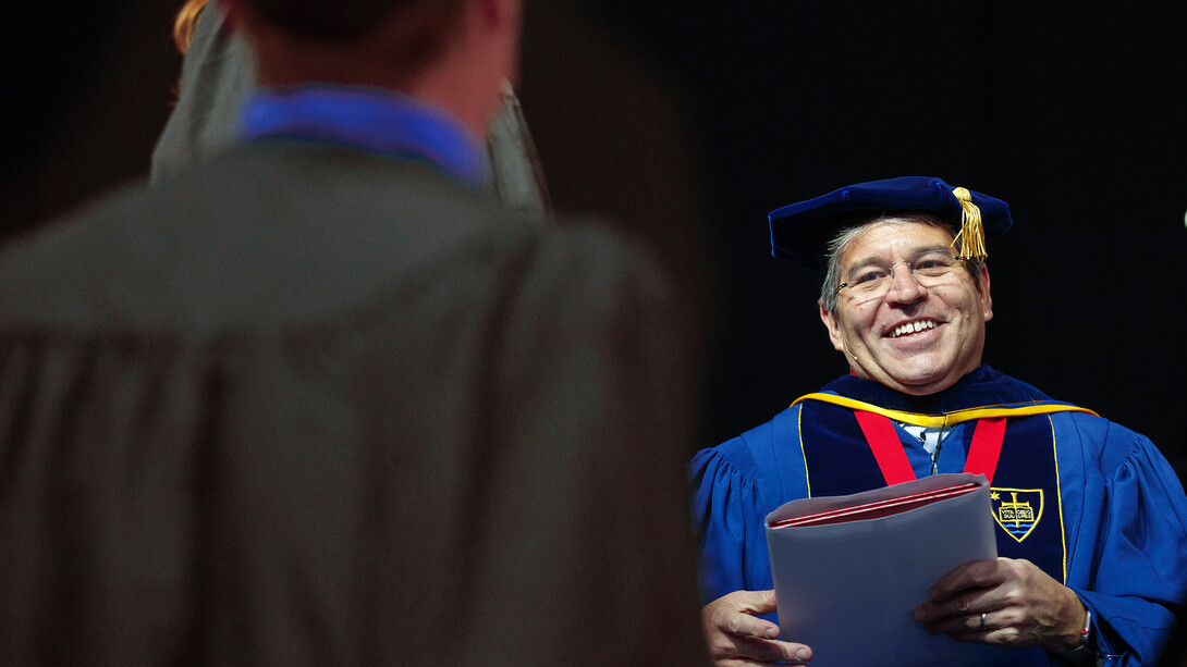 Lance C. Pérez prepares to hand a diploma to a Nebraska Engineering student during the undergraduate commencement ceremony on May 5. Pérez has been named dean of engineering. 