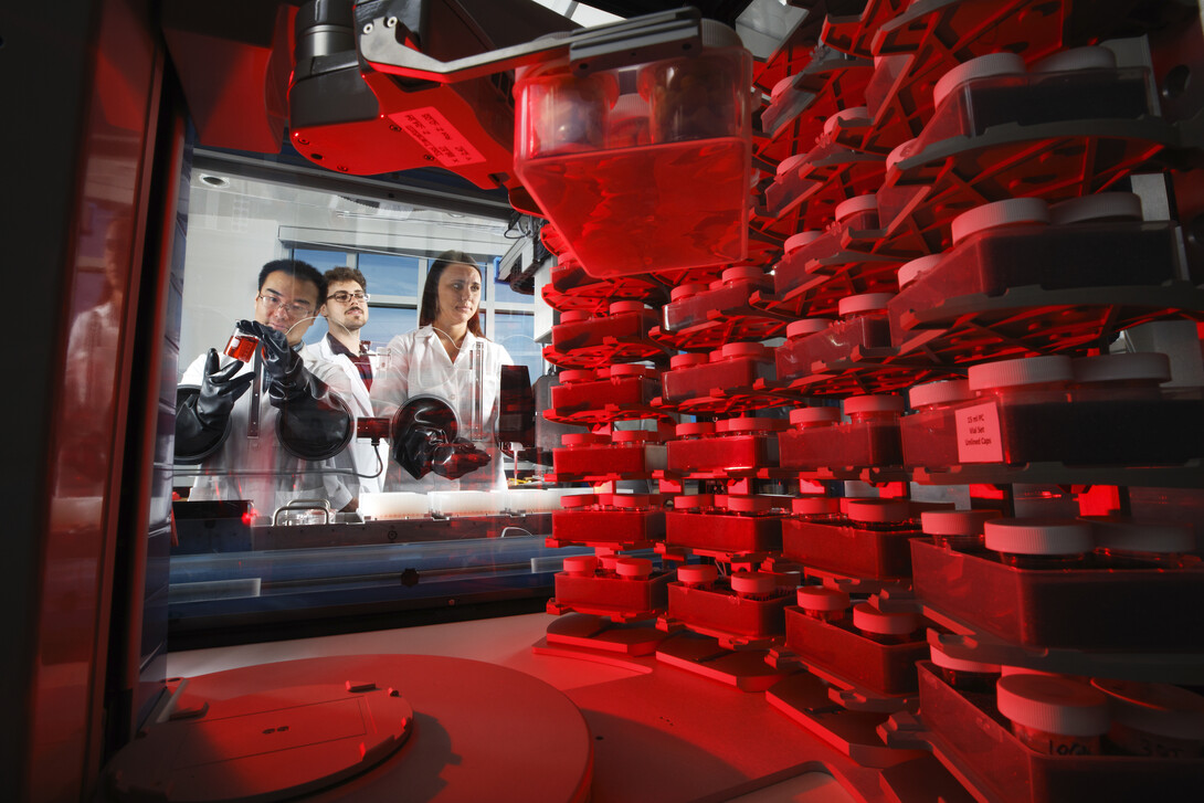 In this 2018 photo, Qinnan Yang, Nate Korth and Mallory Van Haute work with a machine that will deliver small samples of ground grains into fecal samples in the Nebraska Food for Health Center.