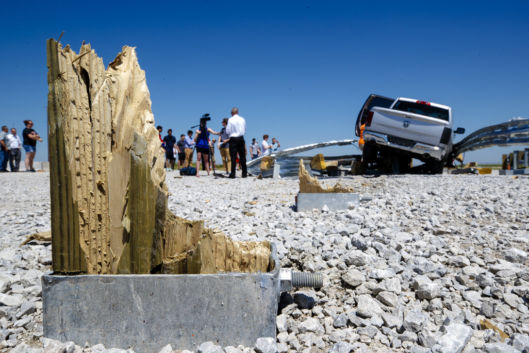 Wood pylons stick up through the ground after a test crash into a barrier at the Midwest Roadside Safety Facility proving grounds. The pylons are designed to snap off while absorbing the energy of the crash to help slowly stop the car.