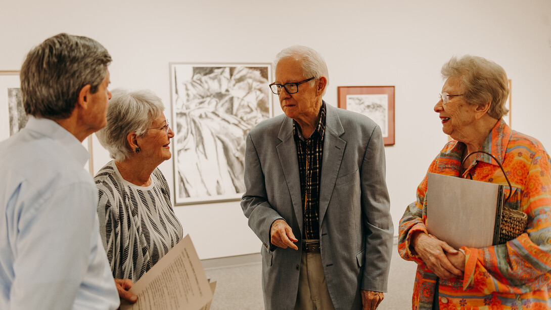 Dan Howard (third from left) and his wife, Barbara, talk with guests during an exhibition opening in the Eisentrager•Howard Gallery in Richards Hall on Sept. 7, 2018.