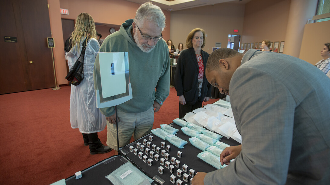 Fred Thorne (left), irrigation manager with landscape services, assists Calvin Sandidge look for his 10-year Service Award prior to the start of the Sept. 25 ceremony in Kimball Recital Hall.