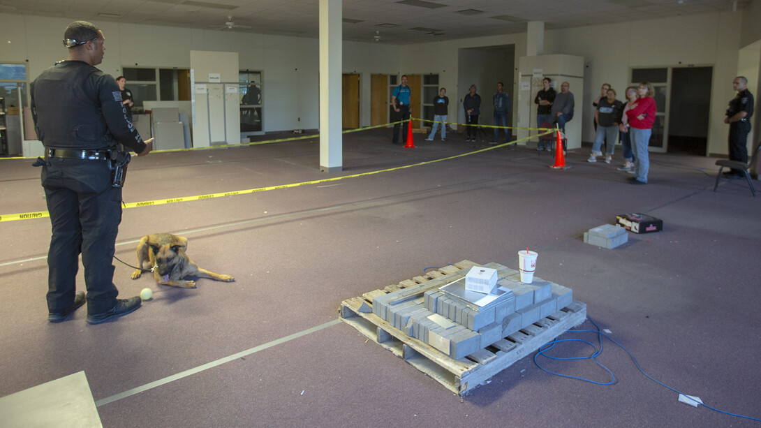 Participants in the Citizens' Police Academy talk with K-9 handler Russell Johnson Jr. after a bomb-detecting demonstration. Johnson's partner is Layla.