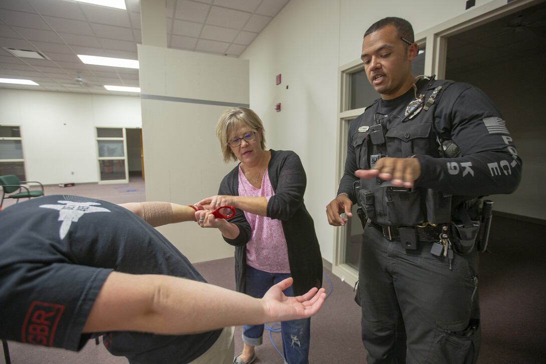 K-9 Officer Russell Johnson Jr. (right) shows Julie Thomsen how to apply handcuffs during the second week of the University Police Department's Citizens' Police Academy. The six-week program is designed to educate members of the campus community about the University Police Department.