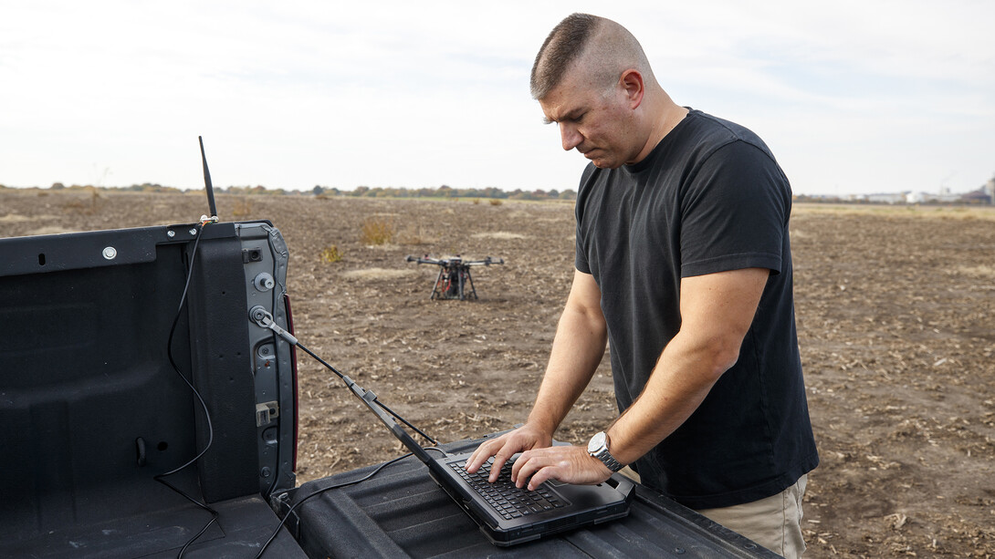 Adam Plowcha checks the status of a drone during a field test. After earning a doctorate, Plowcha hopes to continue working with drones either in academia or industry.