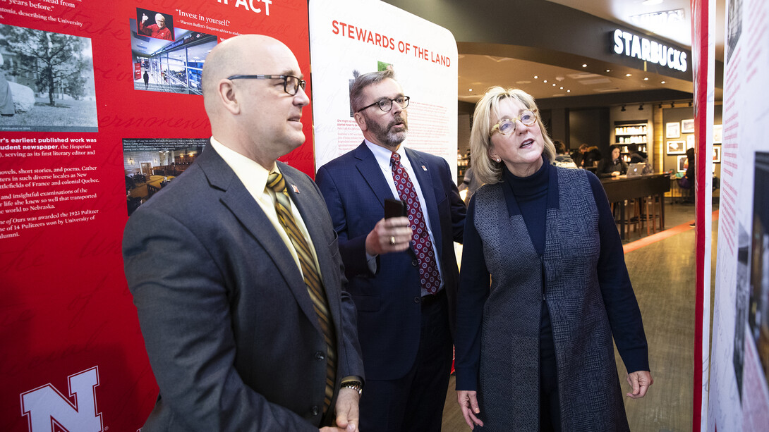 Nebraska's (from left) Mike Boehm, Ronnie Green and Donde Plowman examine the N150 traveling exhibition in the Nebraska Union. The exhibition is on display on campus through Feb. 19.