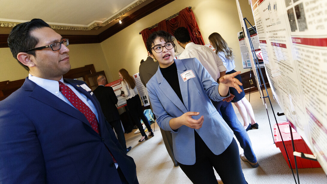 Juliana Rodriguez of Omaha explains her research project, "Surface Interaction of Antibiotic Resistant Bacteria: An Effective Step Towards Robust Biosensor Development," to Sen. Tony Vargas of District 7.