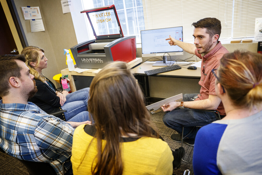 Max Wheeler (pointing to computer screen), NIS instructional designer, leads a training for Library Innovation Studios May 22.