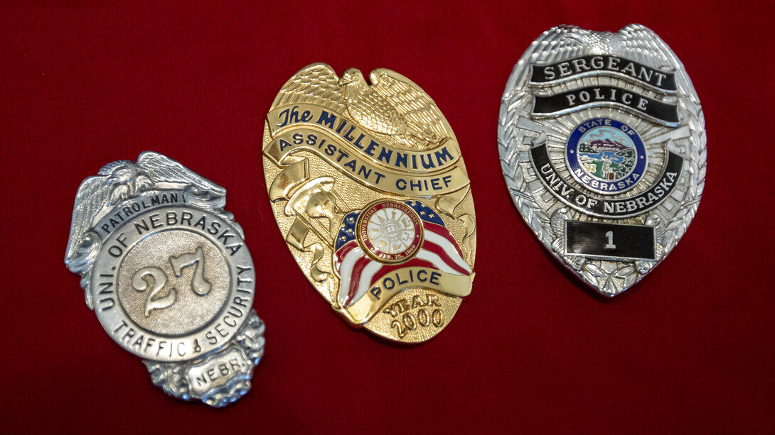  Badges worn by University Police at Nebraska have changed many times through the years. Badges shown (from left) are: a design worn from the 1930s to late 1960s; the millennium badge worn in 2000; and the current regulation design, featuring the Nebraska state seal. These three badges were worn by Bill Manning, who previously served with the University Police and is now with Parking and Transit Services.