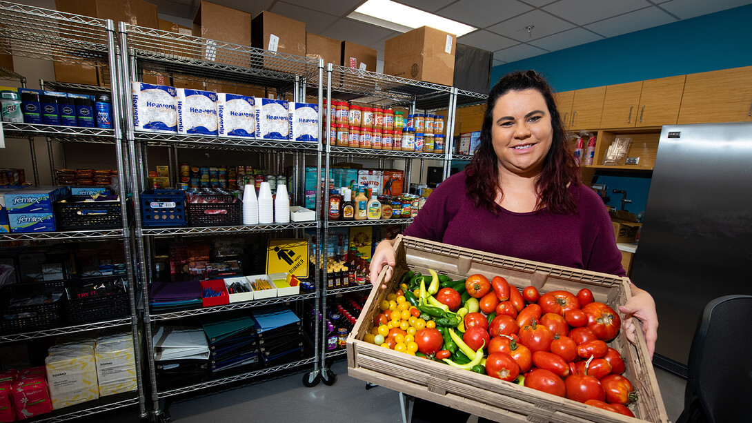 Morgan Smith, a graduate research assistant, shows a tote of fresh vegetables available at Husker Pantry. The pantry and Money Management Center have moved from the Nebraska Union to the University Health Center.