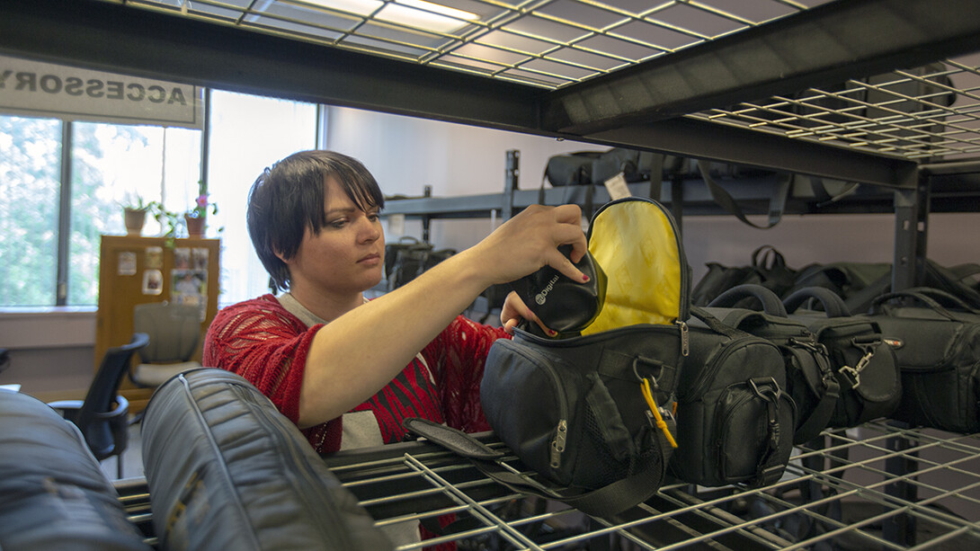 Miranda McCown, media operations supervisor, examines a camera before it is checked out from the Media Services unit within Love Library. The checkout service is located in on the second floor of Love Library North, Room 202.