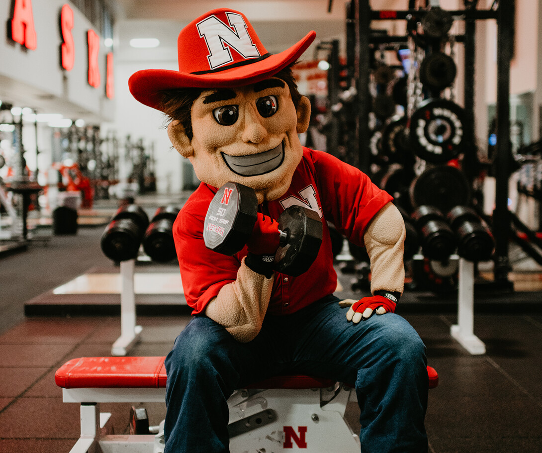 Herbie Husker lifts weights after a morning cheer practice in Memorial Stadium. The mascot's never-say-die work ethic is a reflection of the spirit of all Nebraskans.