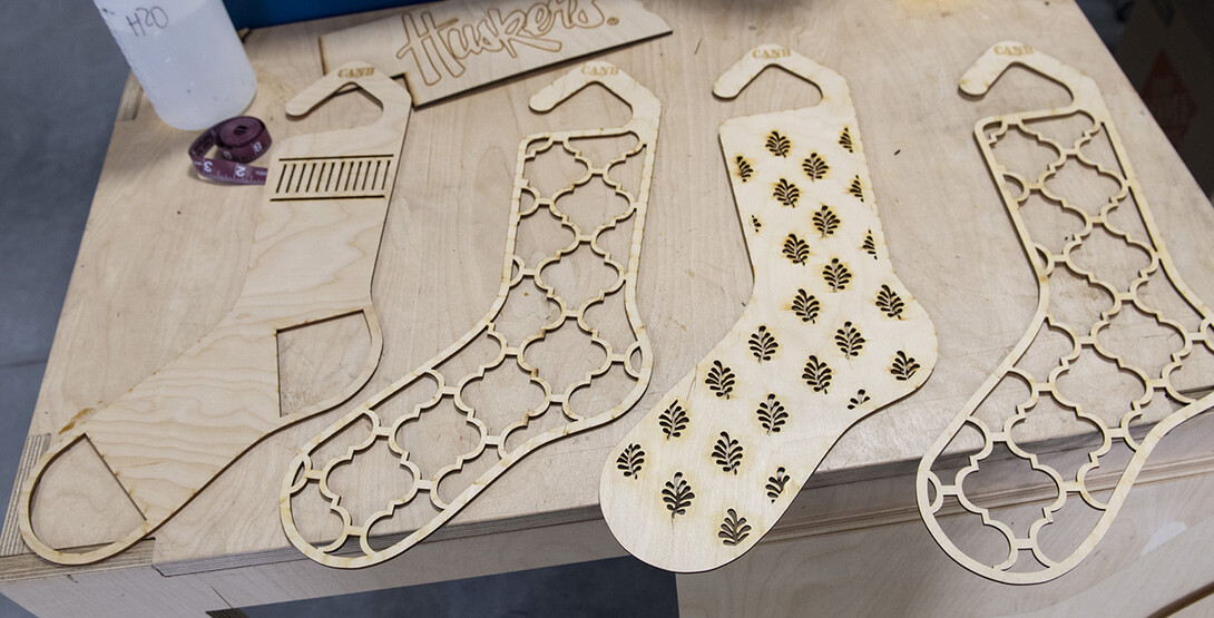 Carly Brotherson pulls sock blocks from the laser cutter at Nebraska Innovation Studio Nov. 25. Brotherson made the sock blocks for a yarn store, which requested the project through the new 'Request a Maker' button, which matches makers to projects. November 25, 2019.