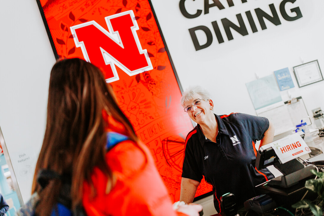 Lory chats with a student at the Cather Dining register